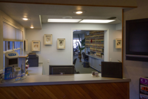 The reception desk at Cocoa Village Dentistry with files neatly shelved, cleared counter space, a TV, and decorations