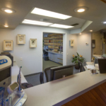 The reception desk at Cocoa Village Dentistry with files neatly shelved, cleared counter space, a TV, and decorations